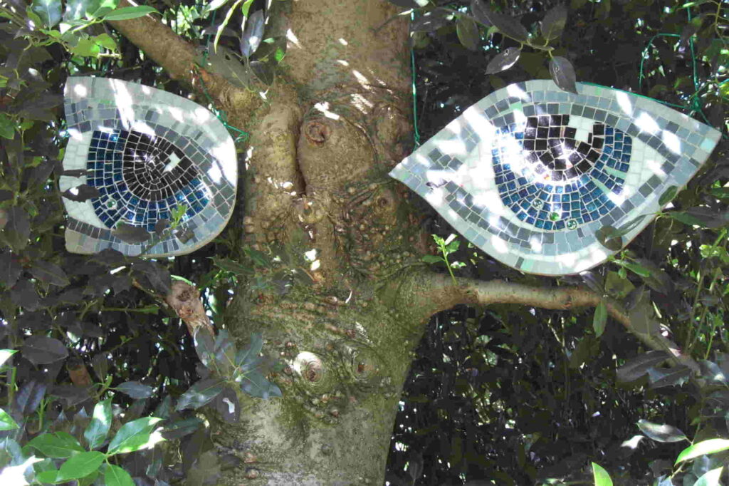 2 Blue mosaic eyes suspended from branches give a creepy image of a tree